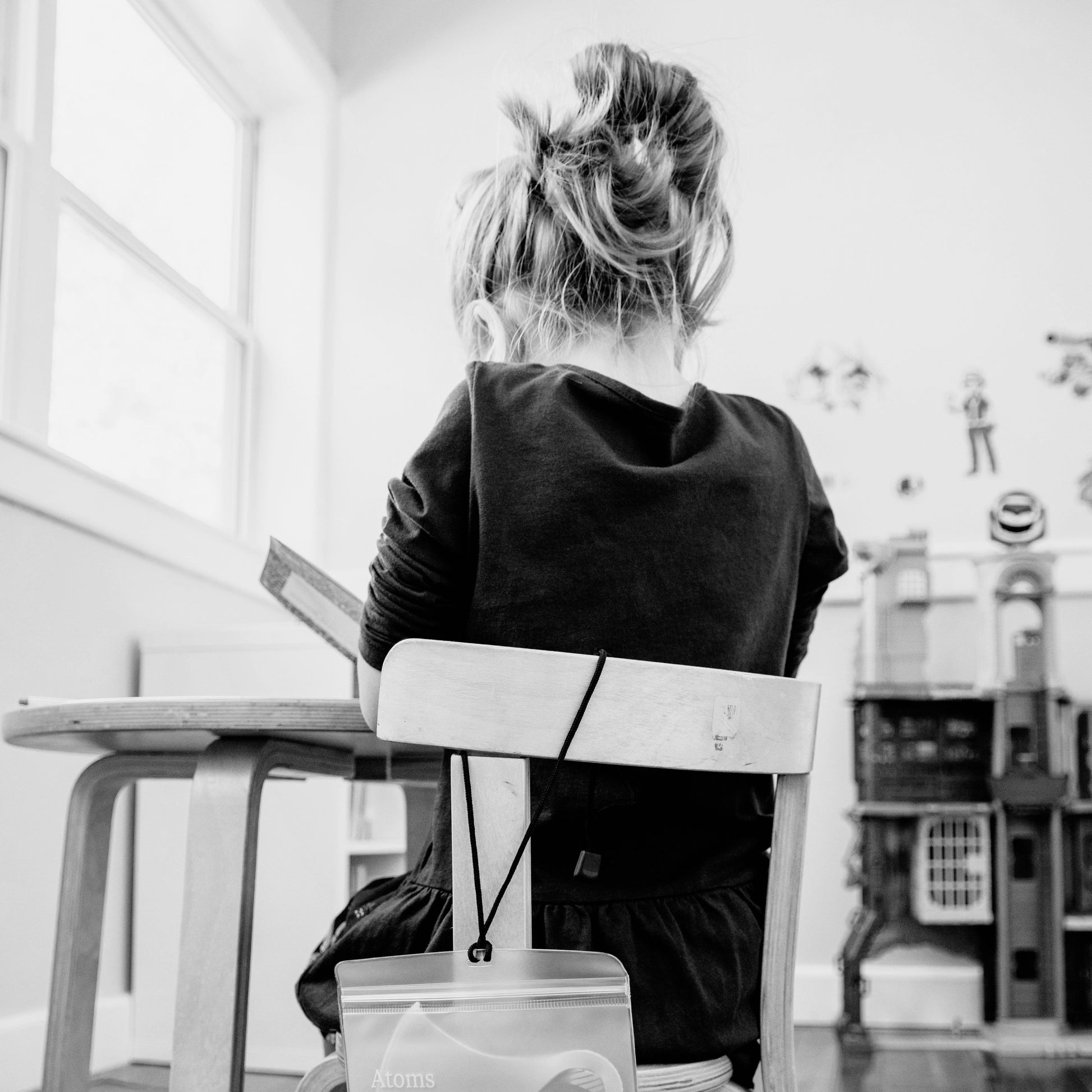 Child sitting at classroom desk using emotional regulation worksheets, supporting focus, reflection and understanding feelings